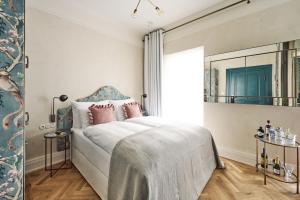 1 dormitorio con cama con almohadas rosas y espejo en Hotel MOTTO, en Viena