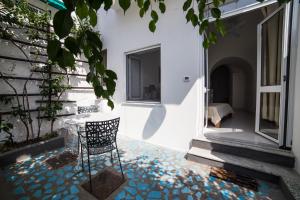 a patio with a table and a chair on a mosaic floor at La Casetta di Sotto in Forio d'Ischia