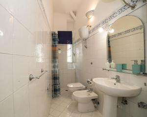 a bathroom with a sink and a toilet and a mirror at La Casetta di Sotto in Forio d'Ischia +23 photos
