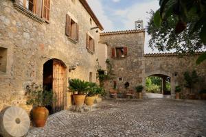 an alley in an old stone building with potted plants at Son Malero in Calvià