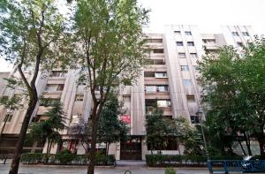 een appartementencomplex met bomen ervoor bij Princesa V in Madrid
