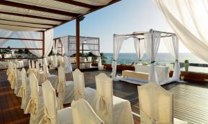 a room with white chairs and tables and the ocean at H10 Gran Tinerfe - Adults Only in Adeje