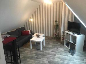 Higgen Adamla في Stedesdorf: غرفة معيشة مع أريكة وتلفزيون