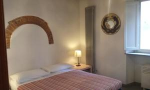ピサにあるB&B Le Donzelle - HiTuscanyのベッドルーム1室(ベッド1台、ランプ、窓付)
