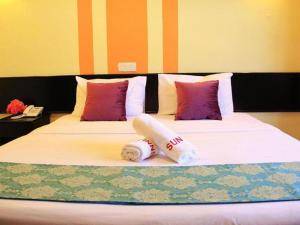 a bed with pillows and towels on it at Sun Inns Kelana Jaya in Petaling Jaya