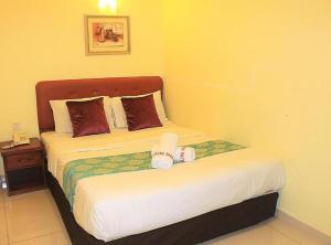 八打靈再也的住宿－Sun Inns Kelana Jaya，一间卧室配有一张床和一个带床罩的床头柜。
