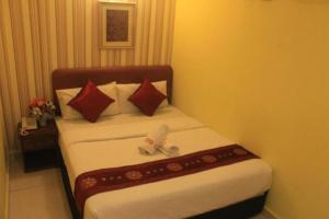 八打靈再也的住宿－Sun Inns Kelana Jaya，配有红色枕头的床的酒店客房