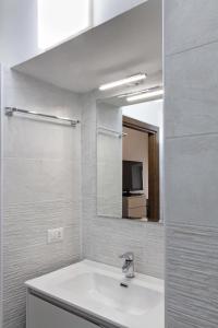 Baño blanco con lavabo y espejo en Vatican Welc-Home, en Roma