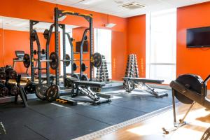a gym with lots of equipment in an orange wall at Motel L Hammarby Sjöstad in Stockholm