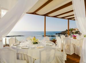 a table with white chairs and a view of the ocean at H10 Gran Tinerfe - Adults Only in Adeje