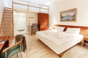 a bedroom with a bed and a desk and a ladder at Hotel Hvide Falk in Ilulissat