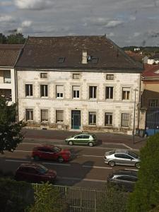 een groot stenen gebouw met auto's geparkeerd op een parkeerplaats bij L’ÉMERAUDE 2 in Châlons-en-Champagne