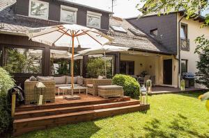 a patio with an umbrella on a deck at Hotel Garni Schick in Oberursel