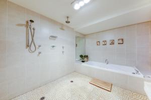uma casa de banho branca com uma banheira e um chuveiro em Taman Sari Luxury Private Pavilions - Pet Friendly Accomodation em Mapleton