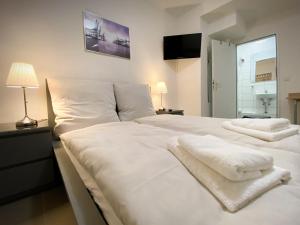 a bedroom with two white beds with towels on them at Sleep In Hamburg Kajüten in Hamburg