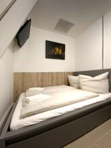 ein Bett mit weißer Bettwäsche und ein TV an der Wand in der Unterkunft Sleep In Hamburg Kajüten in Hamburg