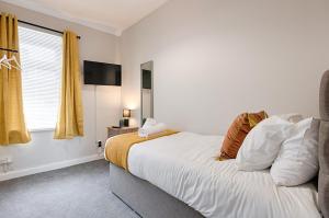 a bedroom with a large bed and a window at Spacious Home - Parking - Kitchen - Ideal for Work in Swansea