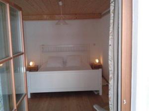 un letto bianco in una camera con due lampade di Haus Perlgut - Maraun Alessia a Rottau
