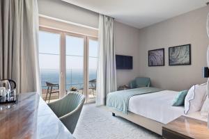 a hotel room with a bed and a view of the ocean at Hotel AMI Budva Petrovac in Petrovac na Moru