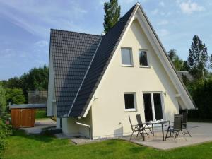 a house with a pitched roof and a patio at Ferienhaus Hagebutte in Quilitz