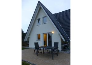 a small white house with a black roof at Ferienhaus Hagebutte in Quilitz