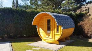 a small wooden dog house sitting in the grass at Ferienhaus Hagebutte in Quilitz