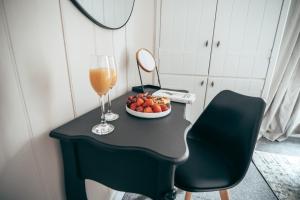 a table with a plate of fruit and a glass of orange juice at City centre Hideaway in Kent
