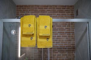 three yellow towels on a towel rack in a bathroom at Quinta dos Caseiros do Paço de Giela in Arcos de Valdevez