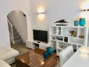 a living room with a couch and a television at Casa Aldea de la Gitana in Estepona