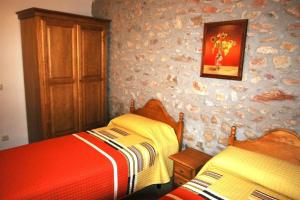 a bedroom with two beds and a painting on the wall at Cal Pedrals II in Urus