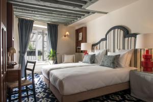 sypialnia z dużym łóżkiem i biurkiem w obiekcie Hôtel Fougère w Paryżu