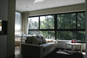 a living room with a couch and a large window at Montseny Suites & Apartments in Montseny