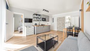 salon z kanapą i stołem w obiekcie Apartamenty Sun & Snow Baltic Apartments z basenem w Pobierowie