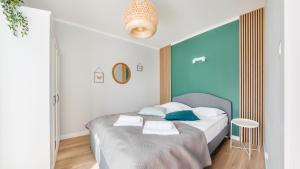 um quarto com uma cama com uma parede azul em Apartamenty Sun & Snow Baltic Apartments z basenem em Pobierowo