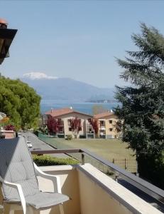 Biały fotel na balkonie z widokiem na wodę w obiekcie LovelyWillyhome w mieście Desenzano del Garda