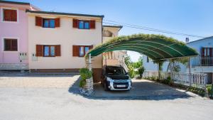 a car parked under an arch in front of a building at Apartment Branko in Šilo