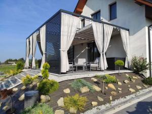 een achtertuin met een patio en een huis bij U Sadzy in Krajno Pierwsze