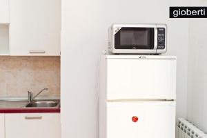 een magnetron bovenop een koelkast in een keuken bij Gioberti in Turijn