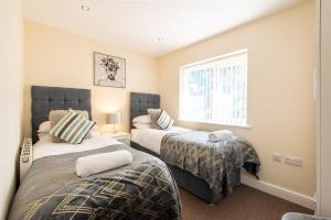 a bedroom with two beds and a window at Apartment 11 in Worksop
