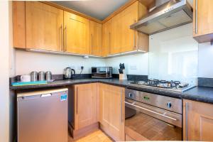 a kitchen with wooden cabinets and stainless steel appliances at Apartment 11 in Worksop