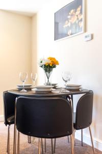 a dining room table with chairs and a vase of flowers at Apartment 11 in Worksop