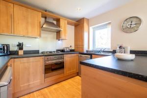 a kitchen with wooden cabinets and a clock on the wall at Apartment 11 in Worksop