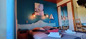 a blue bedroom with a bed with pillows on it at Le Rookie Mountain in Le Grand-Bornand