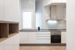 阿利坎特的住宿－Luxury Rental Spain，白色的厨房配有炉灶和窗户。