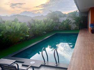 a swimming pool with a view of the water at The Paddy Field - Private Pool Villas in Pantai Cenang