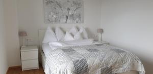 Bed and Breakfast Mittelkärnten في Althofen: غرفة نوم بيضاء بسرير وليلتين