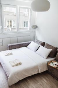 a large bed in a white room with a couch at City Center Studio in Belgrade