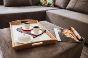 a tray with two cups of coffee on a couch at City Center Studio in Belgrade