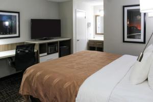 a hotel room with a bed and a flat screen tv at Quality Inn Athens I-65 - Huntsville Area West in Athens