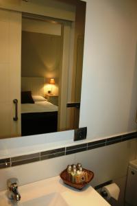 a bathroom with a sink and a mirror at Montseny Suites & Apartments in Montseny